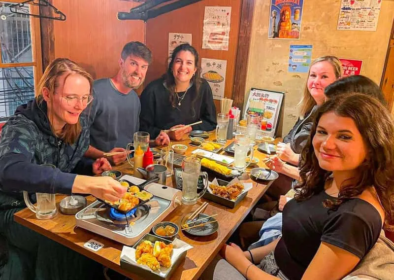 Izakaya dishes and sake shared at night in Pontocho on a gion kyoto food tour, Kyoto, Japan